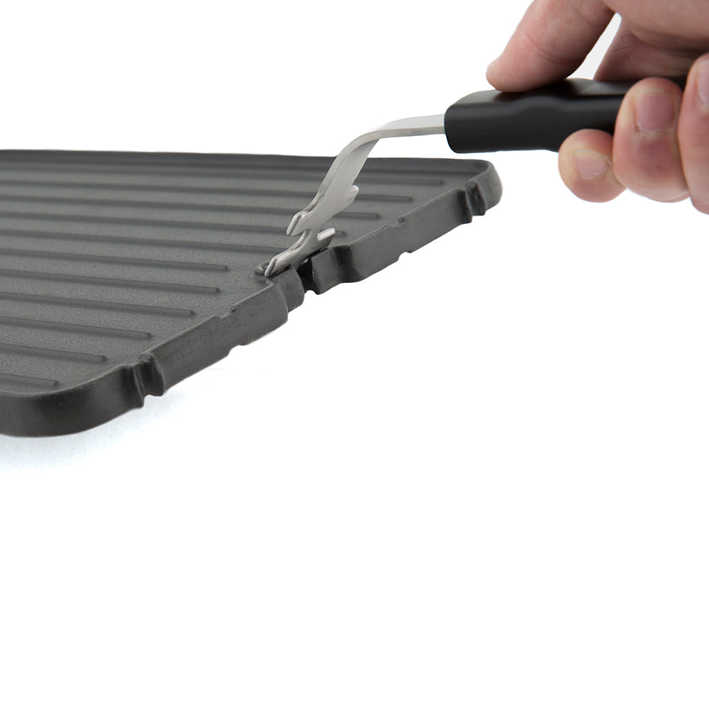 Cast iron griddle edge with metal support tool and black grip