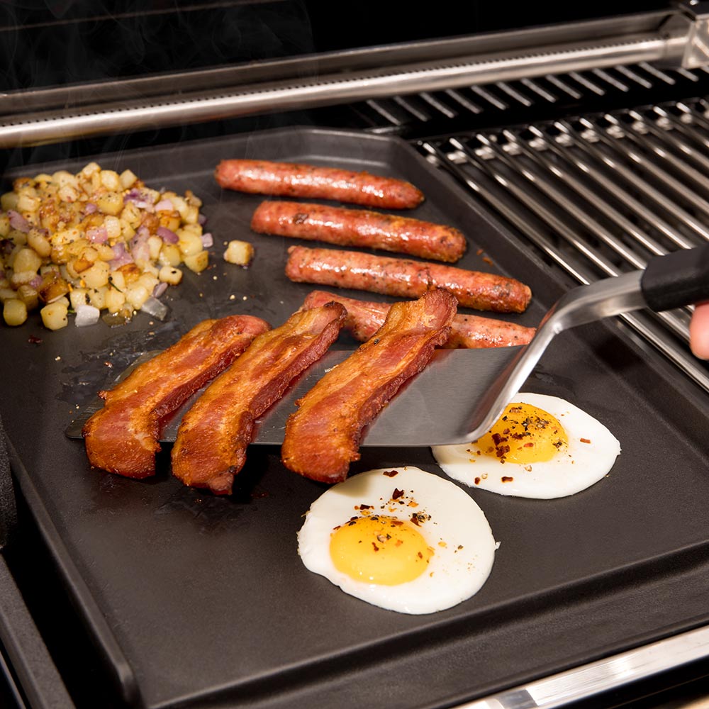 Cast iron griddle plancha with sausages, diced mix, and two fried eggs