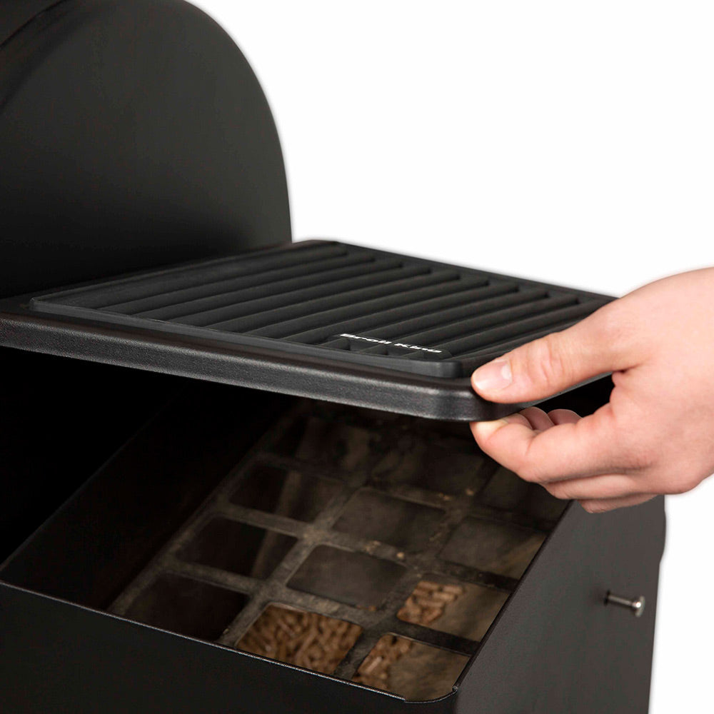 Broil King silicone side shelf mat being placed on grill shelf, black ridges