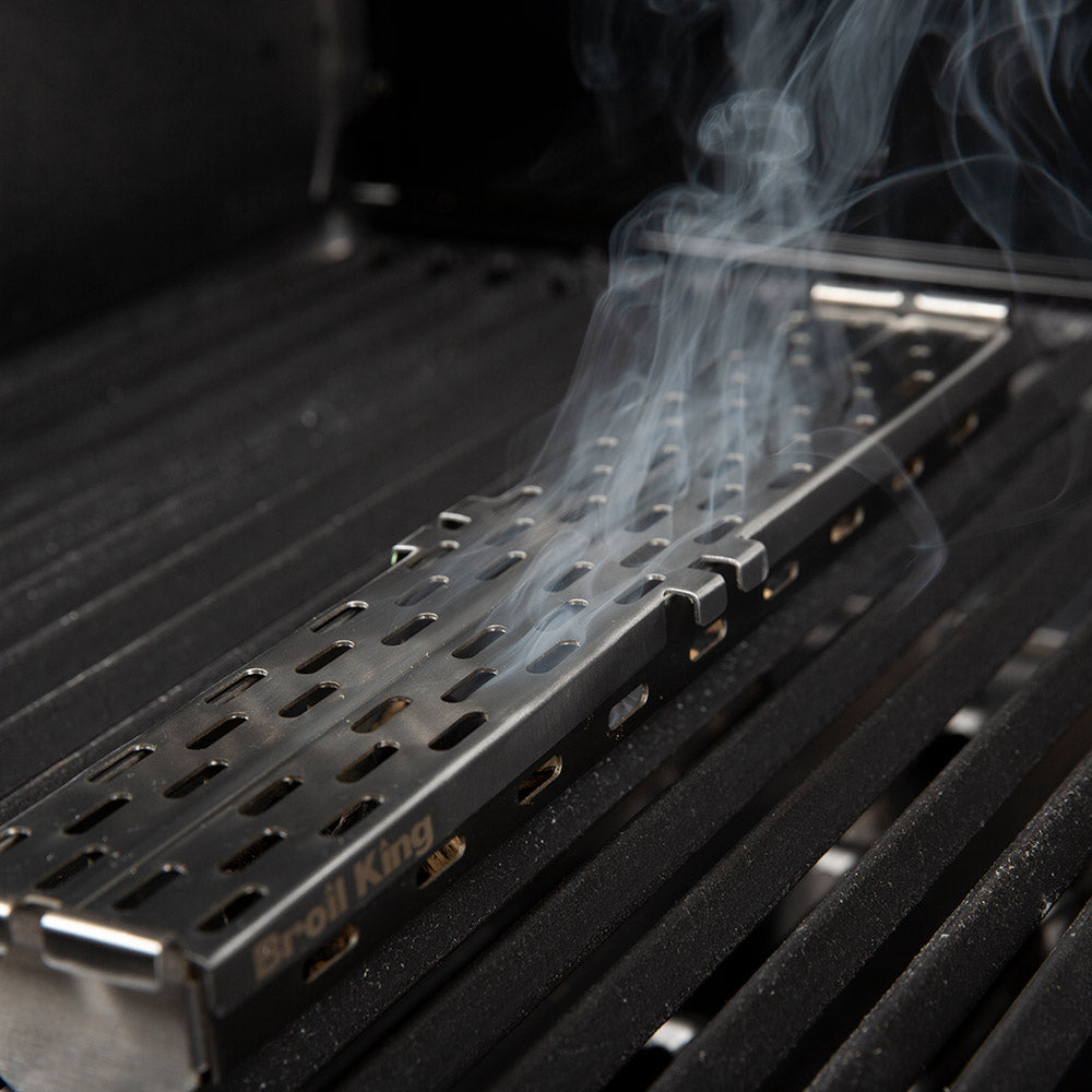 Stainless steel pellet smoker box with perforated tray and visible smoke