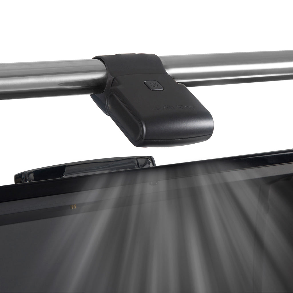 Black grill light clamped to a metal grill tube with lens facing the cooking surface