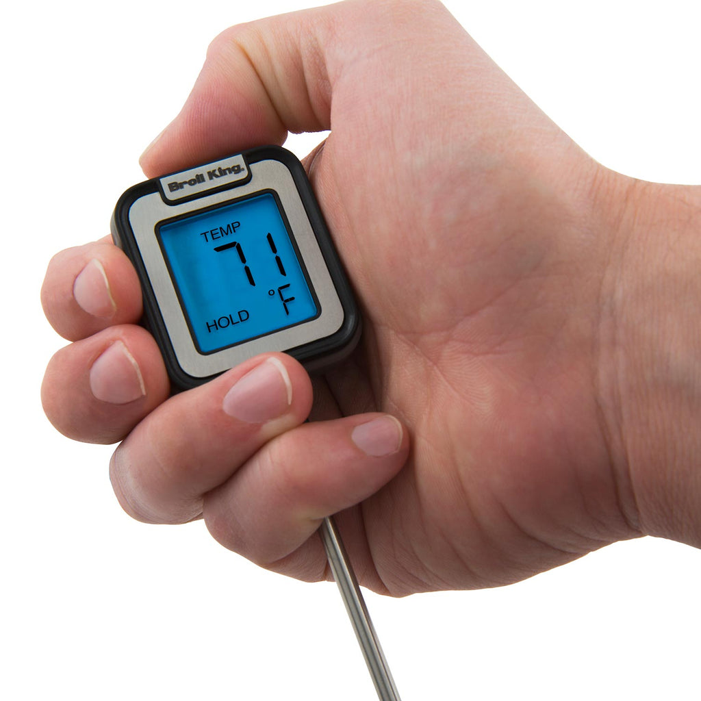 Hand holding instant read thermometer with stainless probe tip and blue LCD temperature