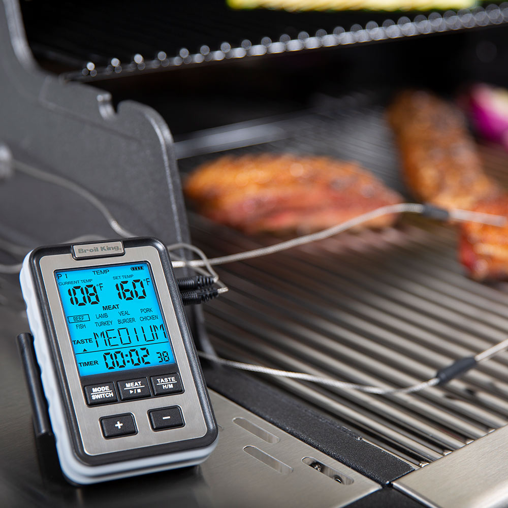 Broil King thermometer on grill grate with connected probe cables and blue temperature display