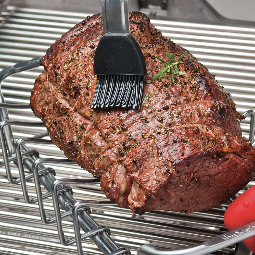 Stainless rib and roast rack supporting a seasoned roast on grill grates, brushed