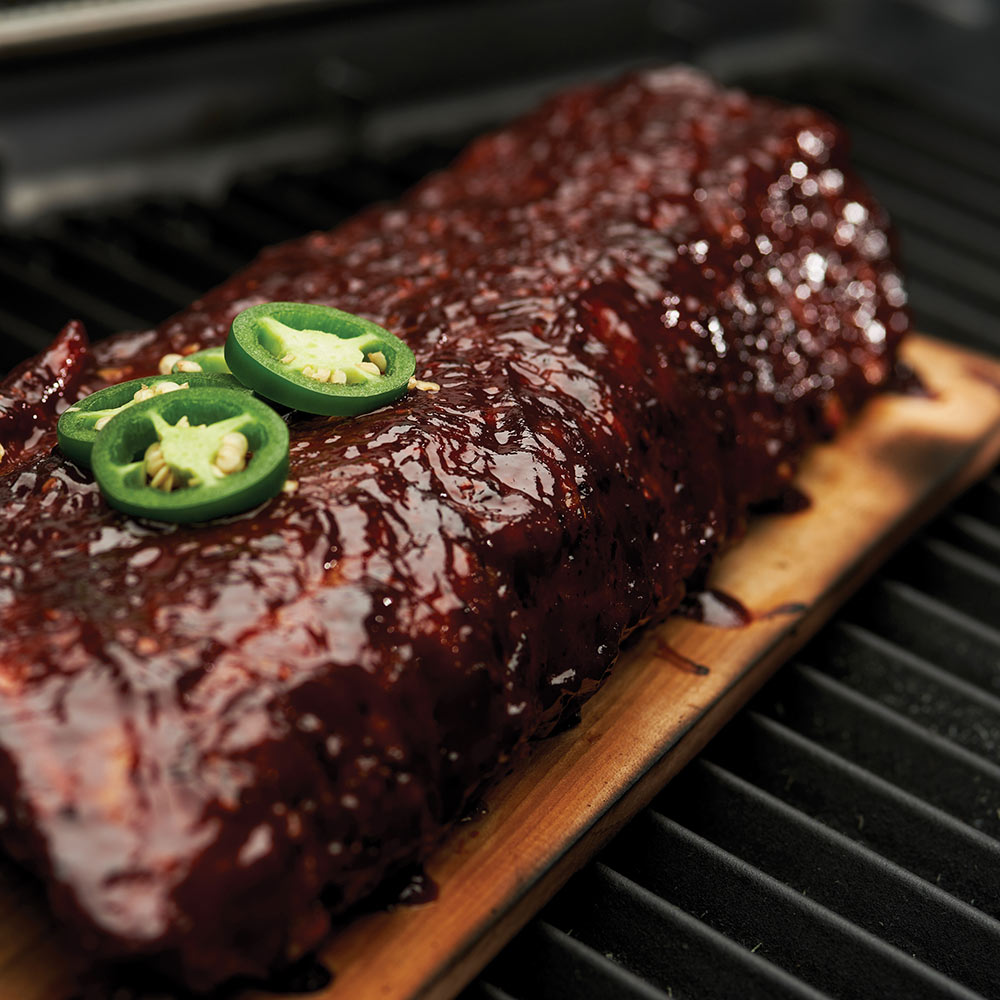 Maple grilling plank with grilled meat and jalapeño slices on top