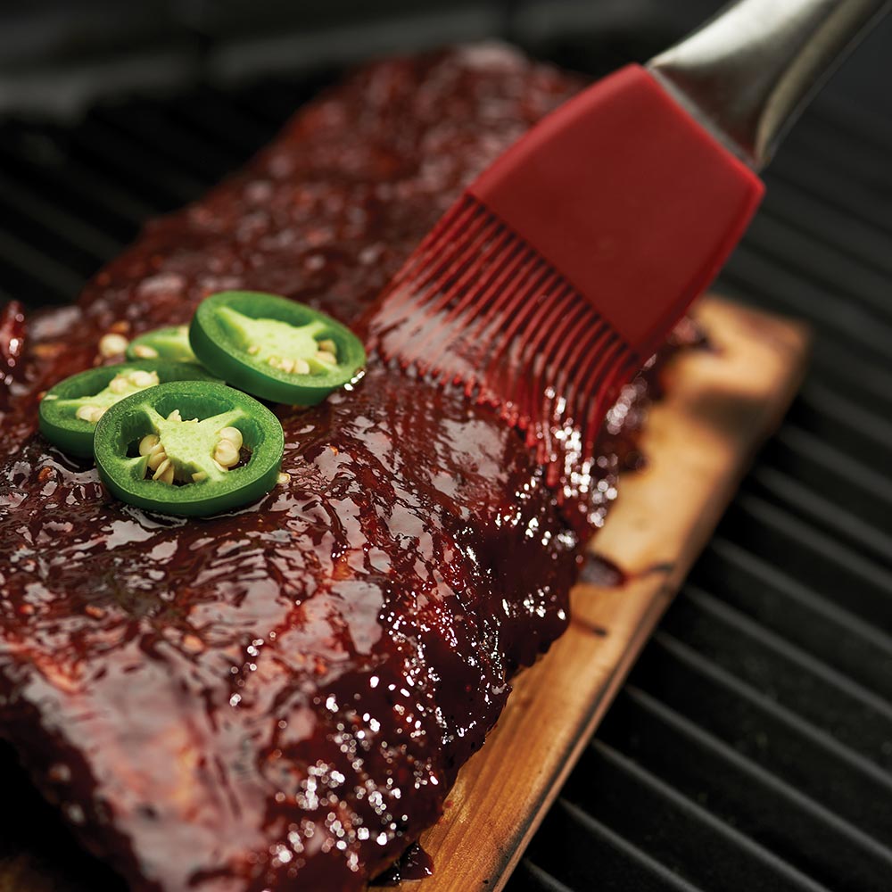 Maple grilling plank with grilled meat, jalapeño slices, and sauce brush