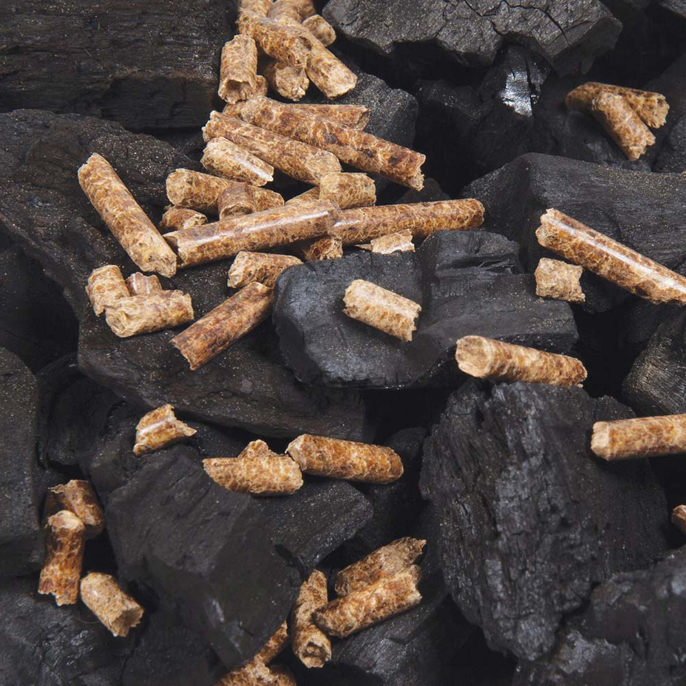 Wood pellets on charcoal pieces, dark brown pellets over black fuel