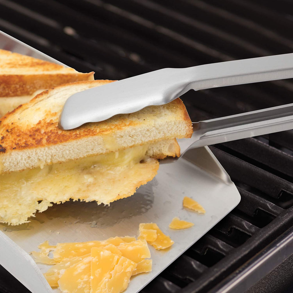 Broil King grill tool set spatula holding toast with melted cheese over grill grates