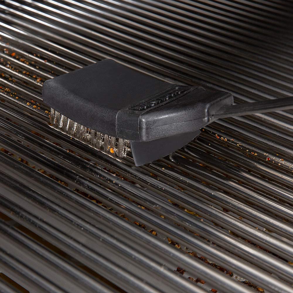 Grill brush head on metal grill grates with stiff bristles
