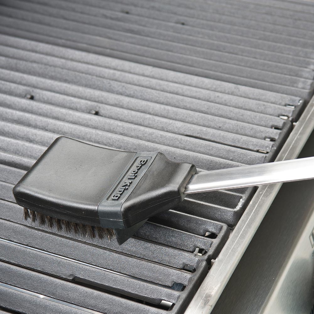 Grill brush on stainless grill grates with bristle head and scraper