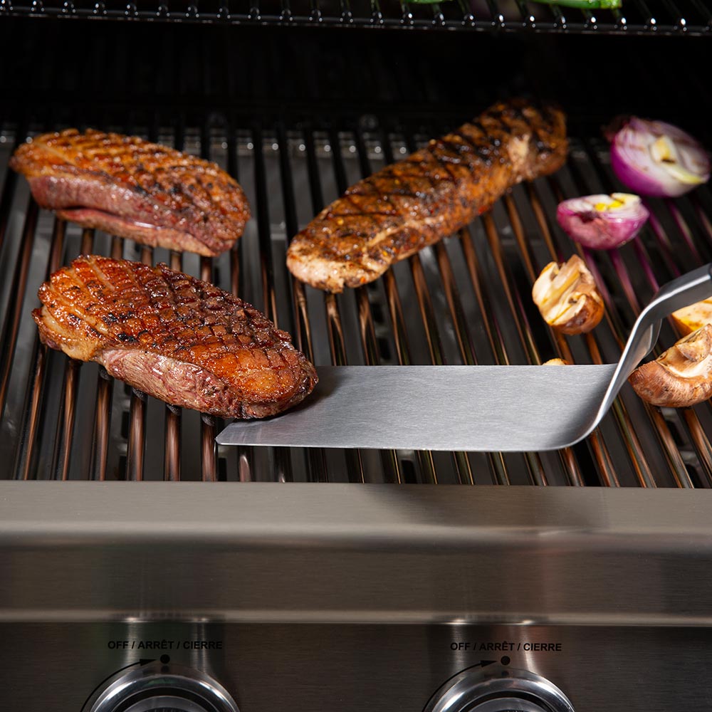 Baron Super Flipper spatula blade resting on grill with black handle