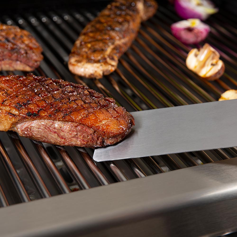 Baron Super Flipper spatula in use, wide stainless-steel blade and black handle