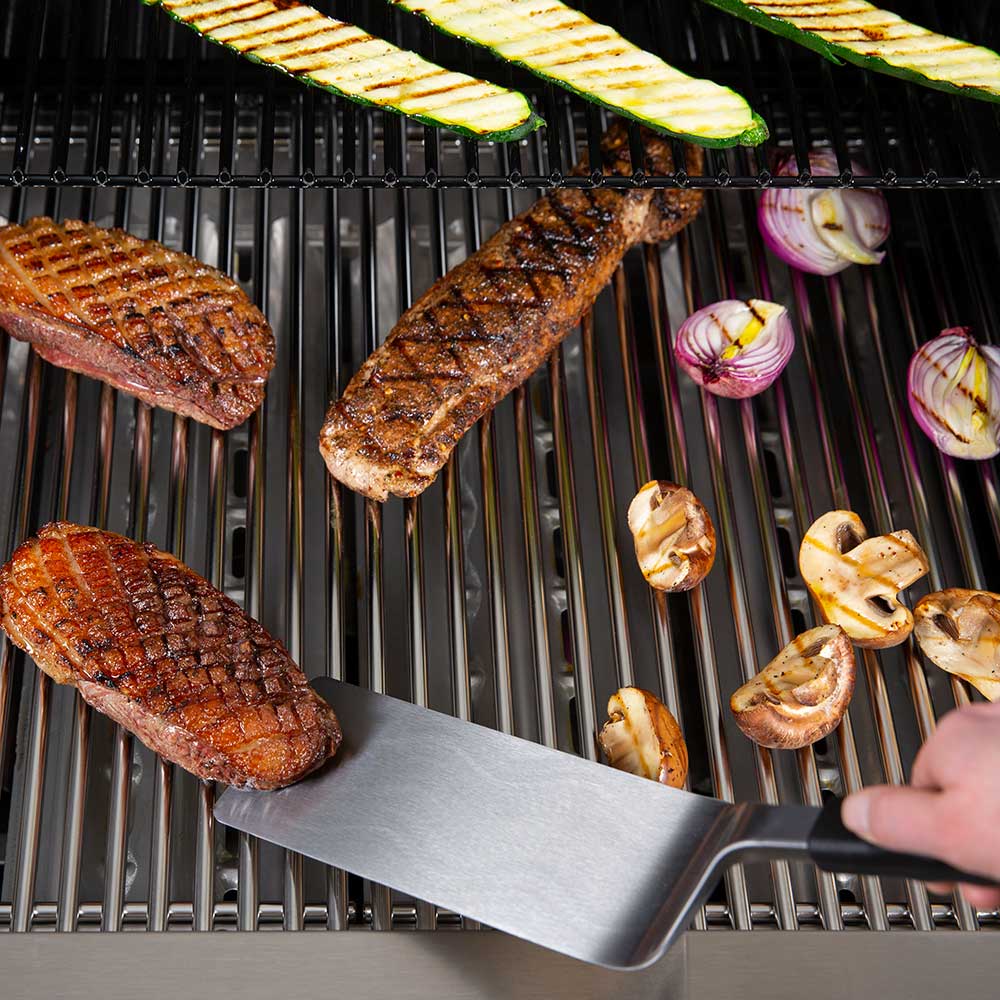 Baron Super Flipper spatula blade positioned on grill with black handle