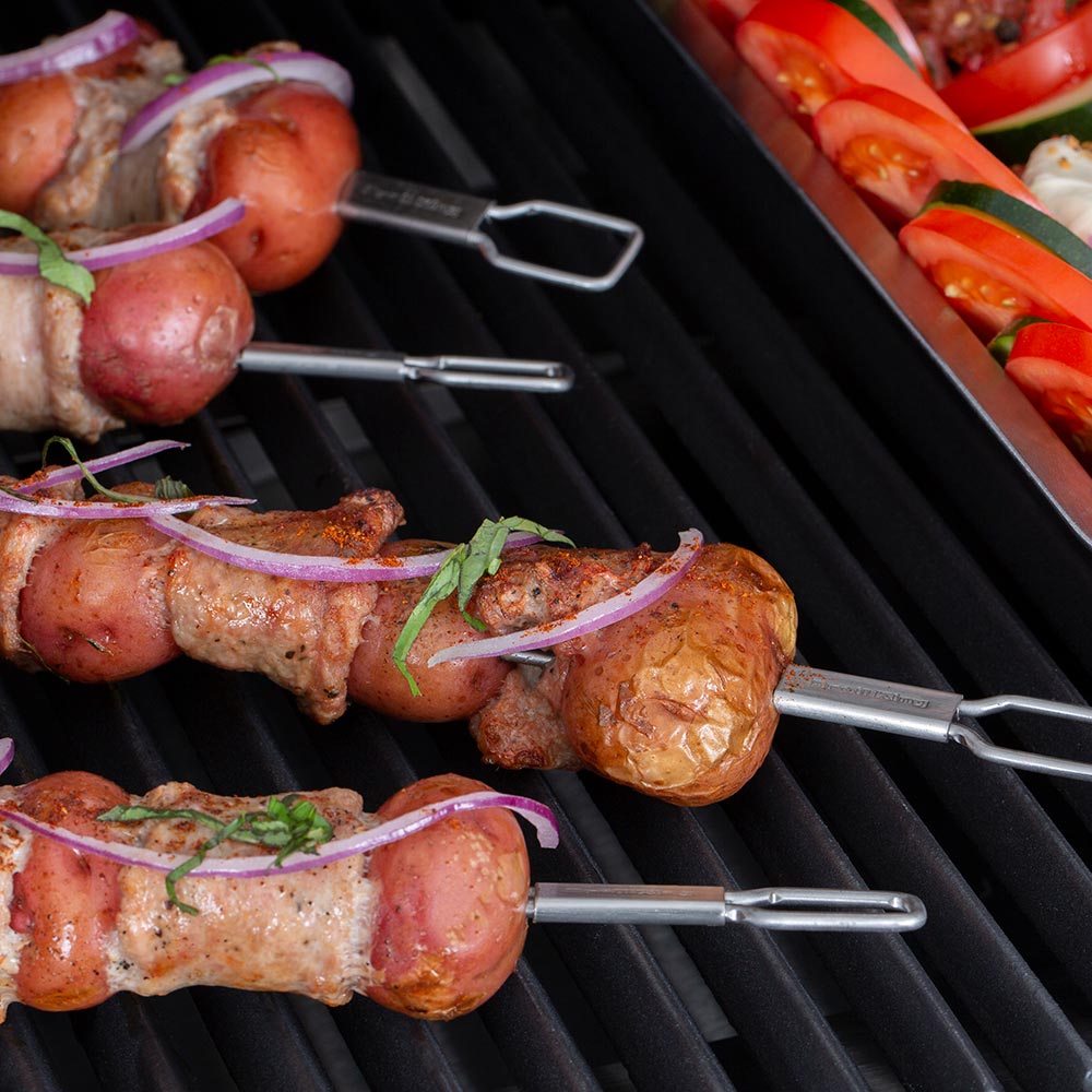Stainless steel dual-prong skewers with grilled sausages and vegetables