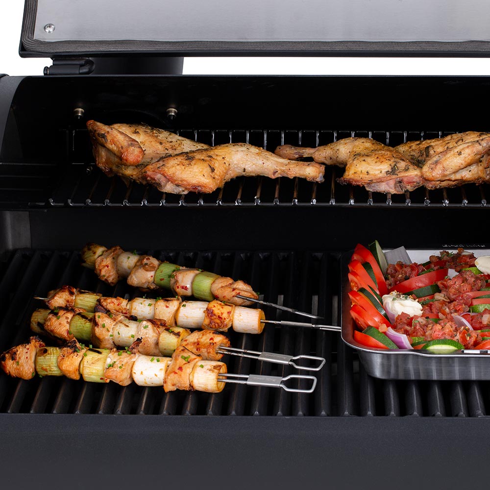Stainless steel dual-prong skewers with grilled meat and vegetables on a barbecue