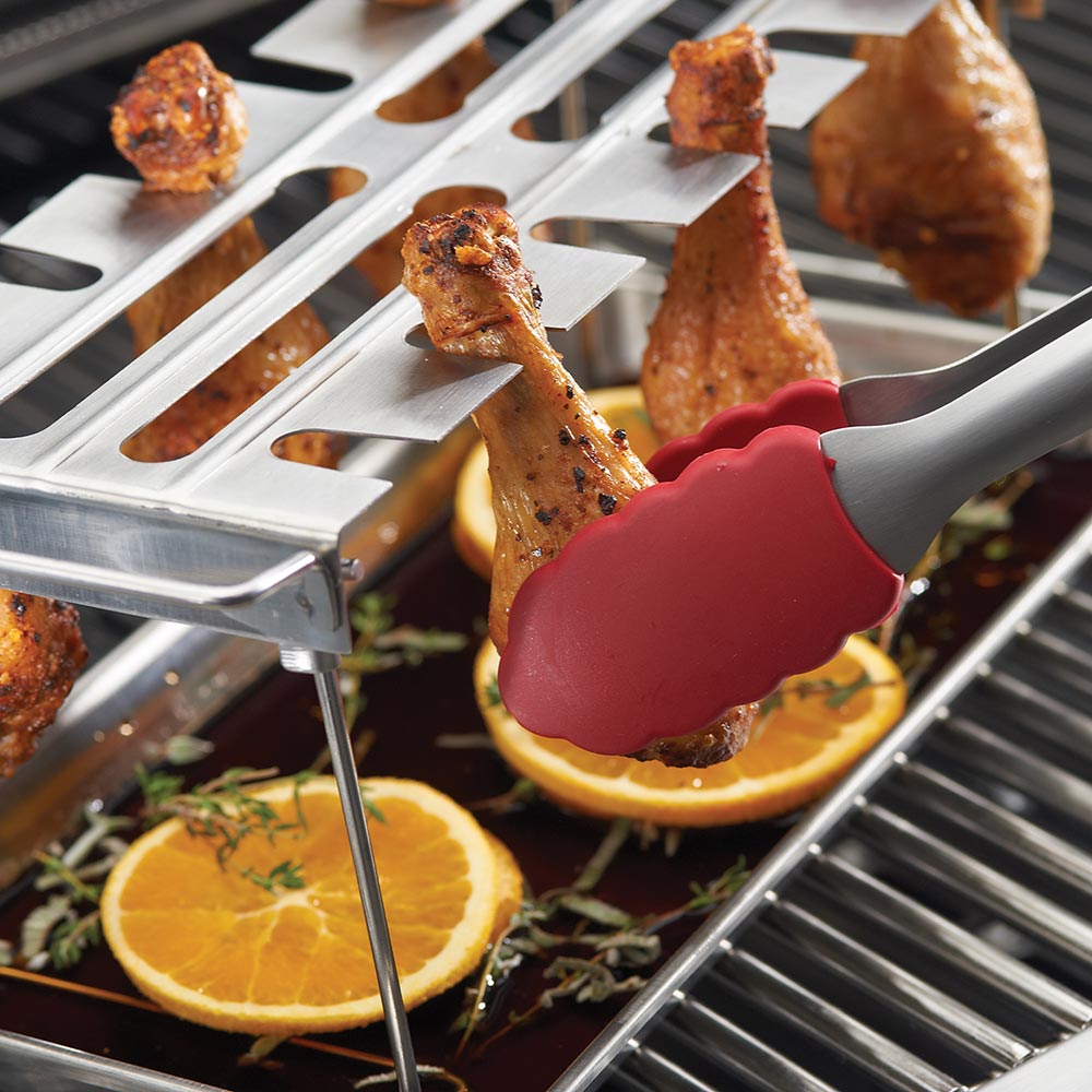 Stainless steel wing rack grid with roasted chicken wings and orange slices