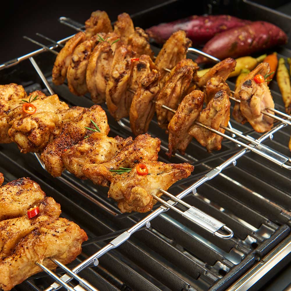 Stainless steel skewer rack on grill with assorted chicken skewers