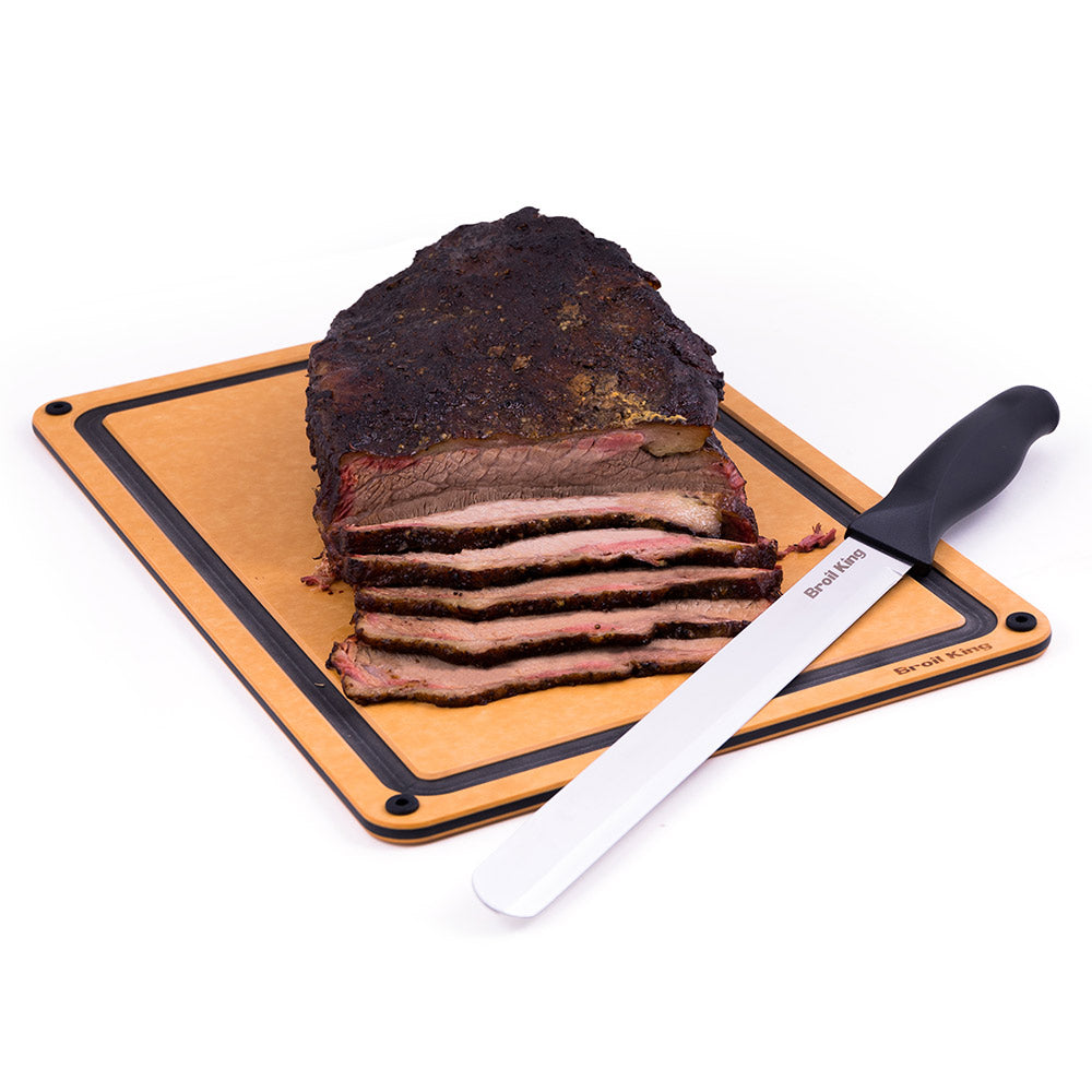 Carving knife with black handle and silver blade beside sliced brisket