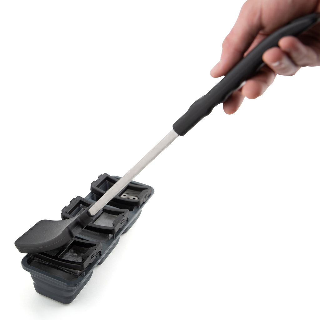 Ice grill brush close-up with scraper head contacting the ice tray