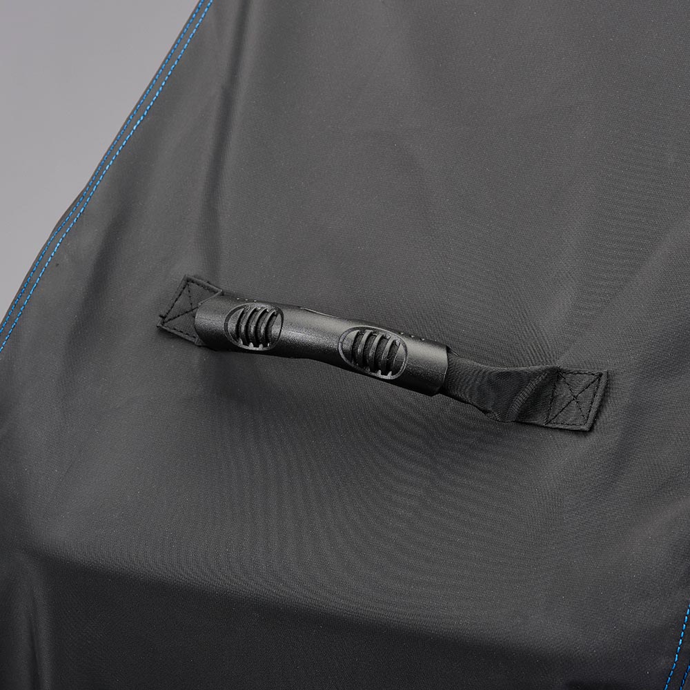 Grill cover tie-down strap on dark gray polyester fabric with blue edging.