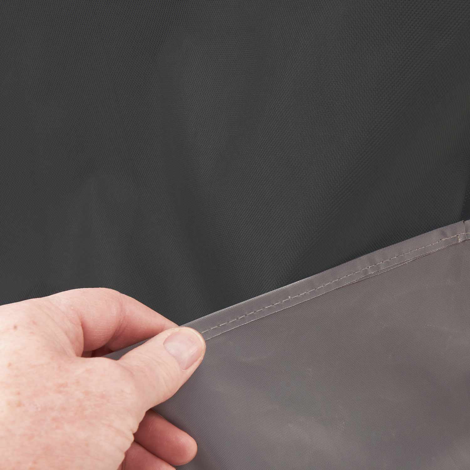 Grill cover edge with stitched seam and fabric texture, dark gray