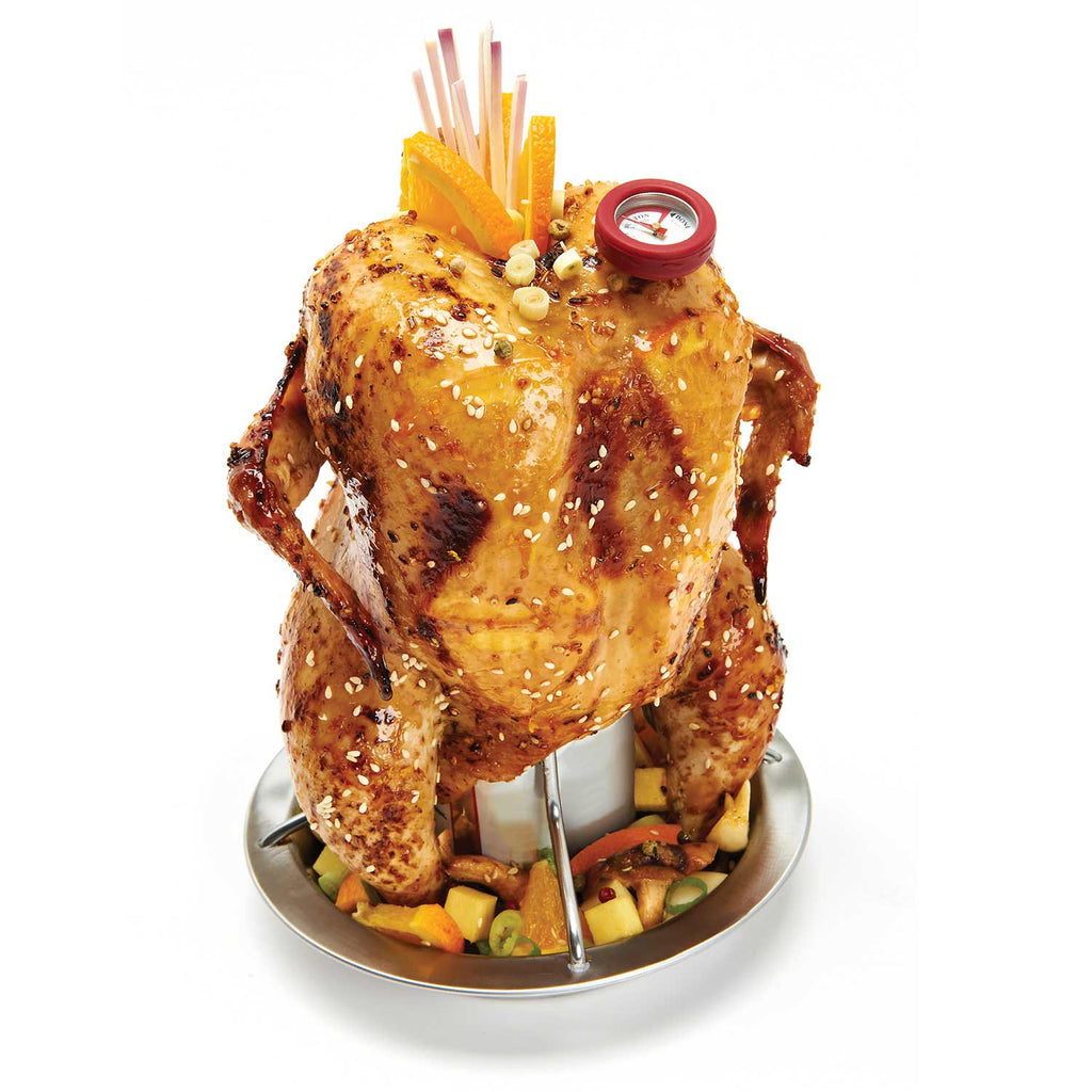 Whole roasted chicken on a vertical roaster stand with vegetables in the tray