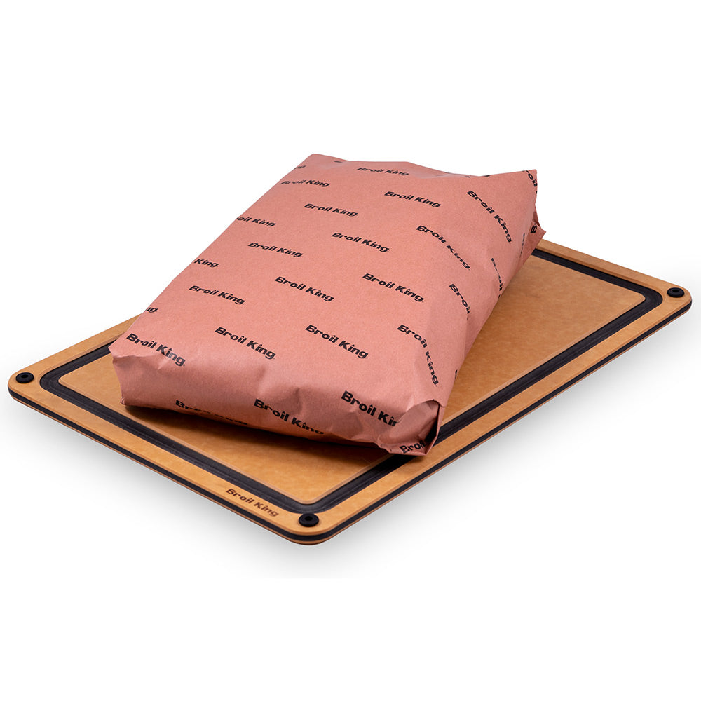 Butcher paper wrap on a wooden cutting board, pink with repeating Broil King logo print