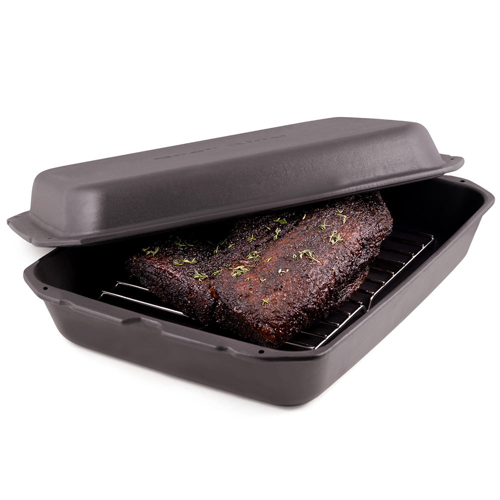 Cast iron multi roaster with lid, holding a seared roast on inner rack