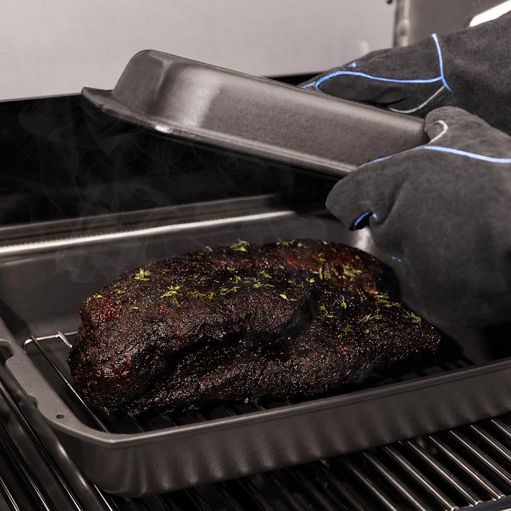 Cast iron multi roaster with roast, lid propped open for easy access