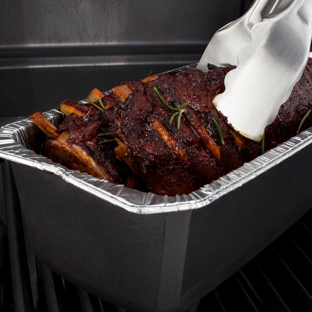 Aluminum foil roaster liner with cooked ribs and wide spatula