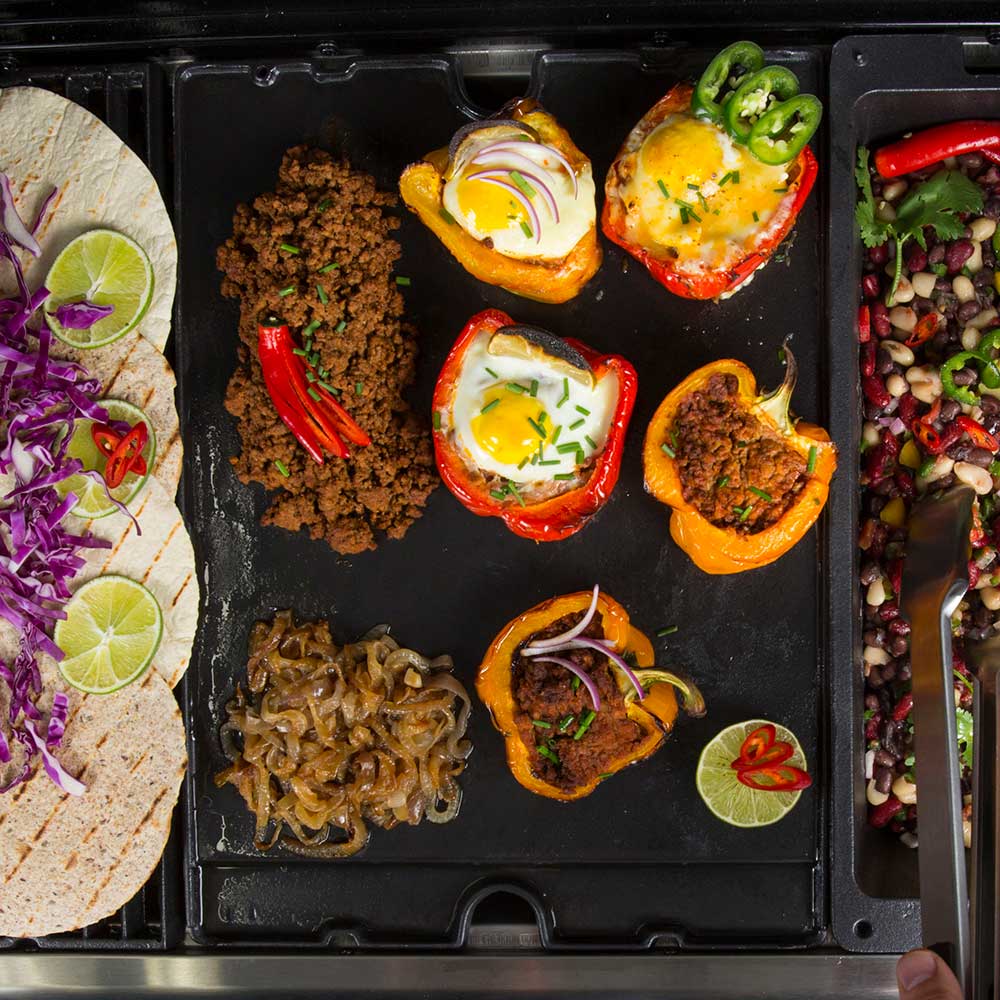 Cast iron grill wok tray with cooked peppers, onions, and meat pieces