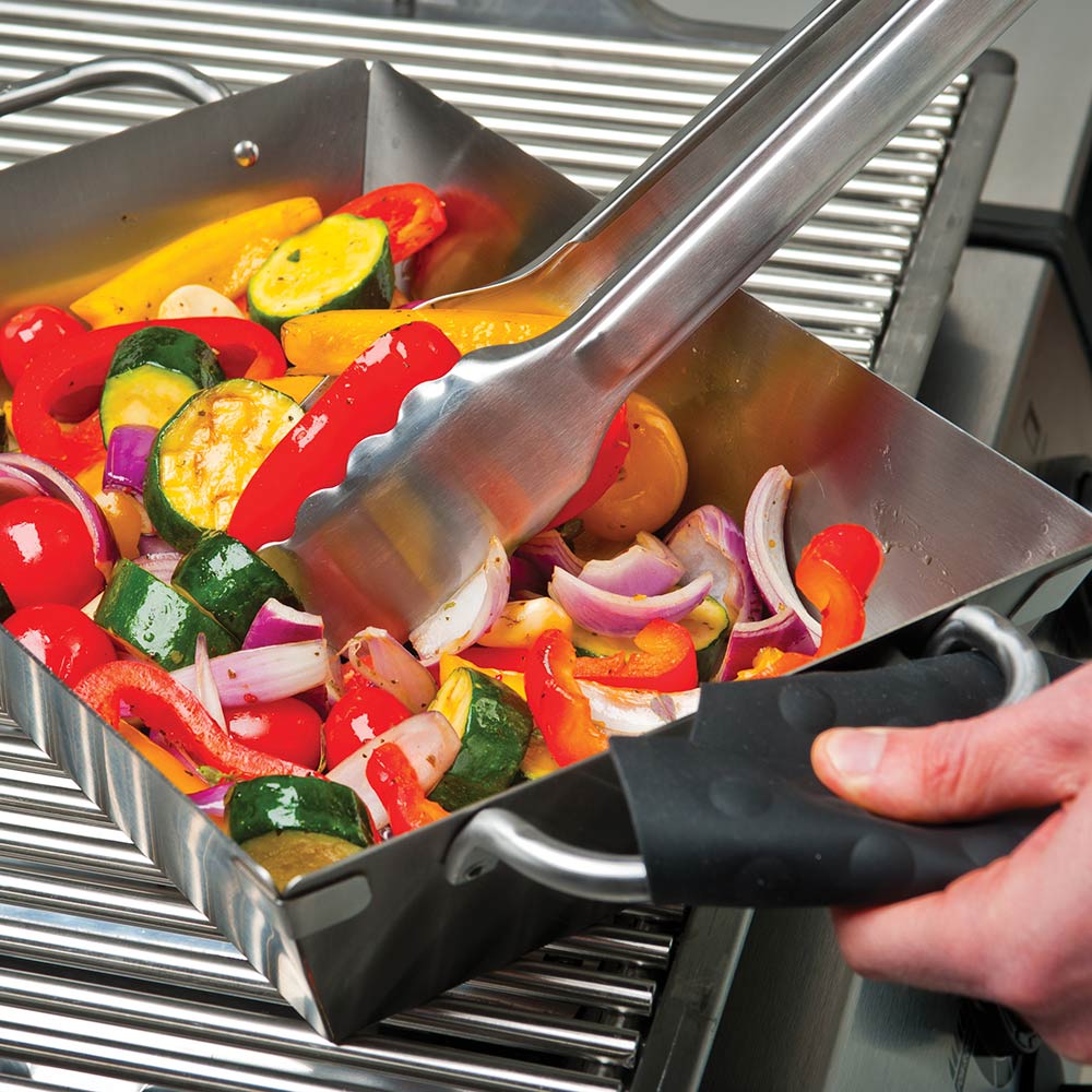 Stainless steel wok with mixed peppers and onions and a black handle utensil