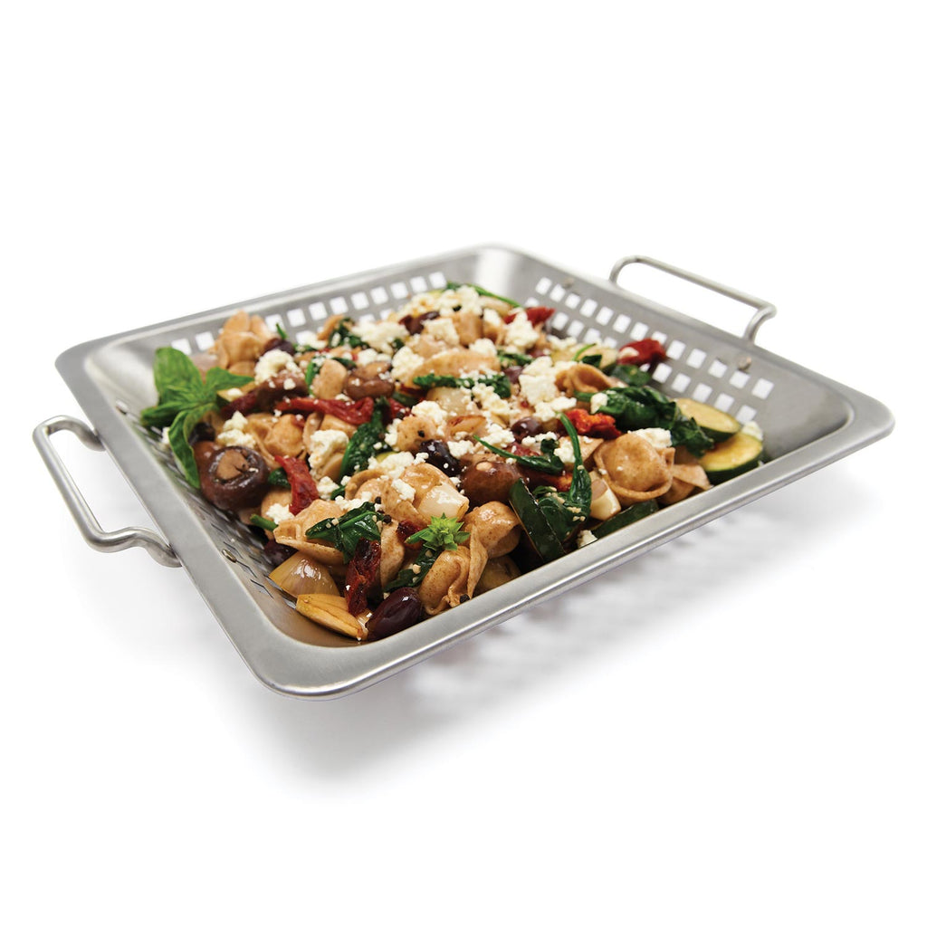 Stainless steel wok grill topper with side handles, filled with grilled vegetables and meat