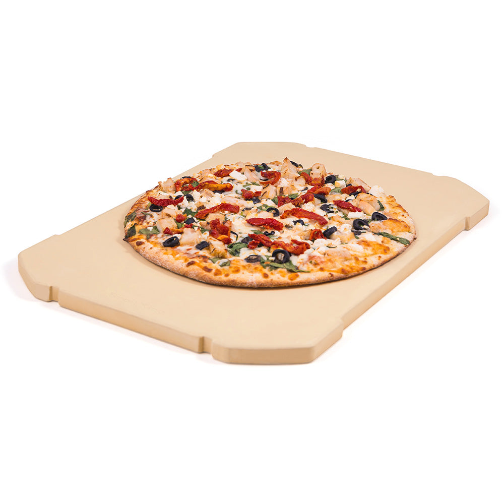 Rectangular pizza stone with topped pizza on a light tan ceramic surface