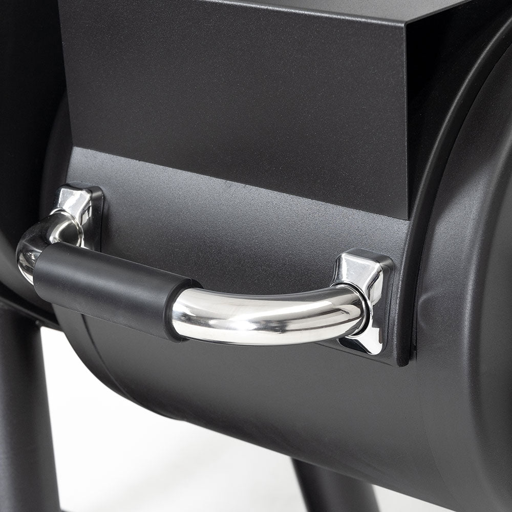Smoker firebox door with black grip and chrome latch on dark charcoal body