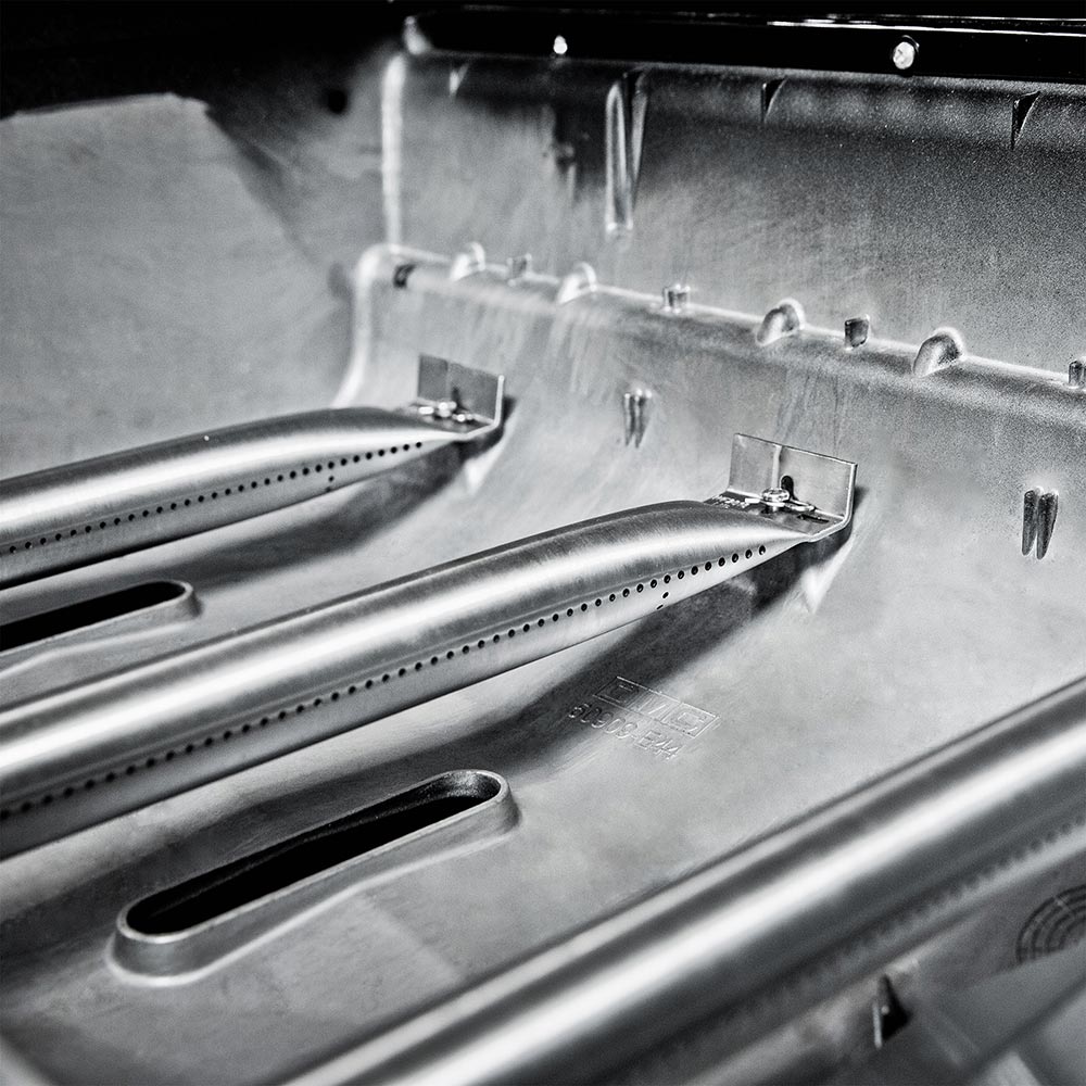 Stainless steel burner tubes and heat shields inside gas grill cooking area