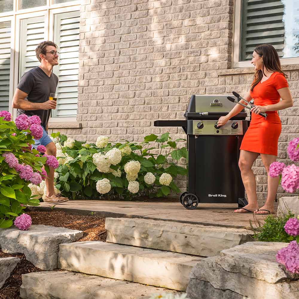 Broil King 3-burner propane grill on two-wheel cart, black finish with side shelves