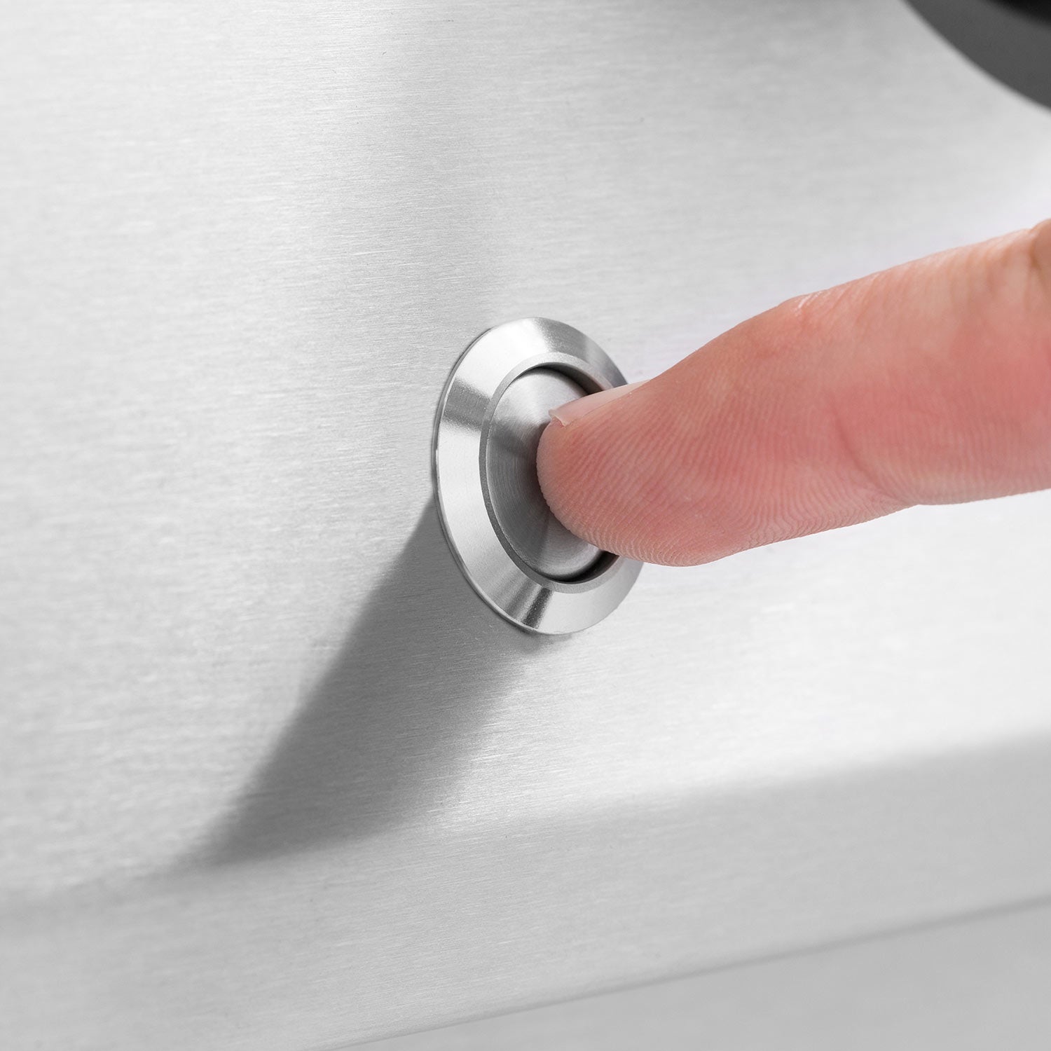 Stainless steel grill control knob with a finger turning the dial