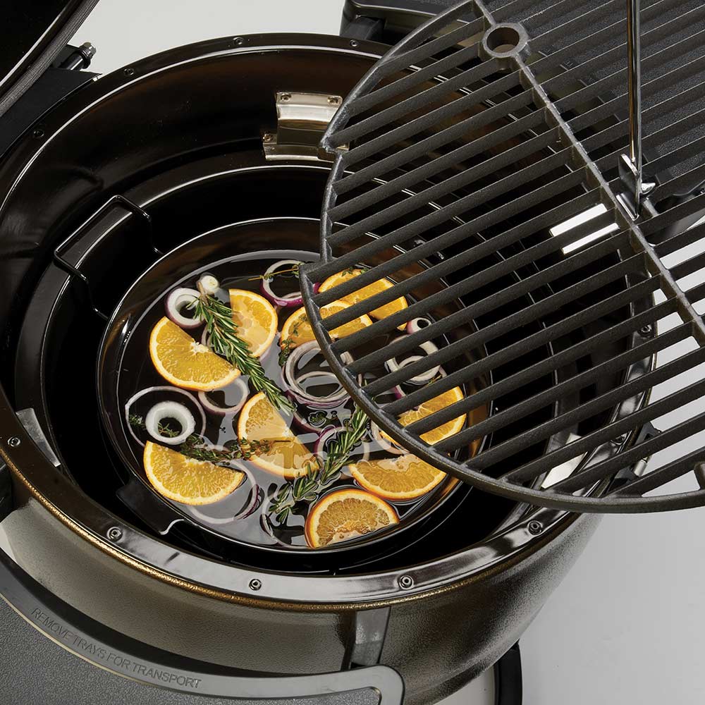 Wire slatted grill diffuser ring above lemon slices and herbs on the grill