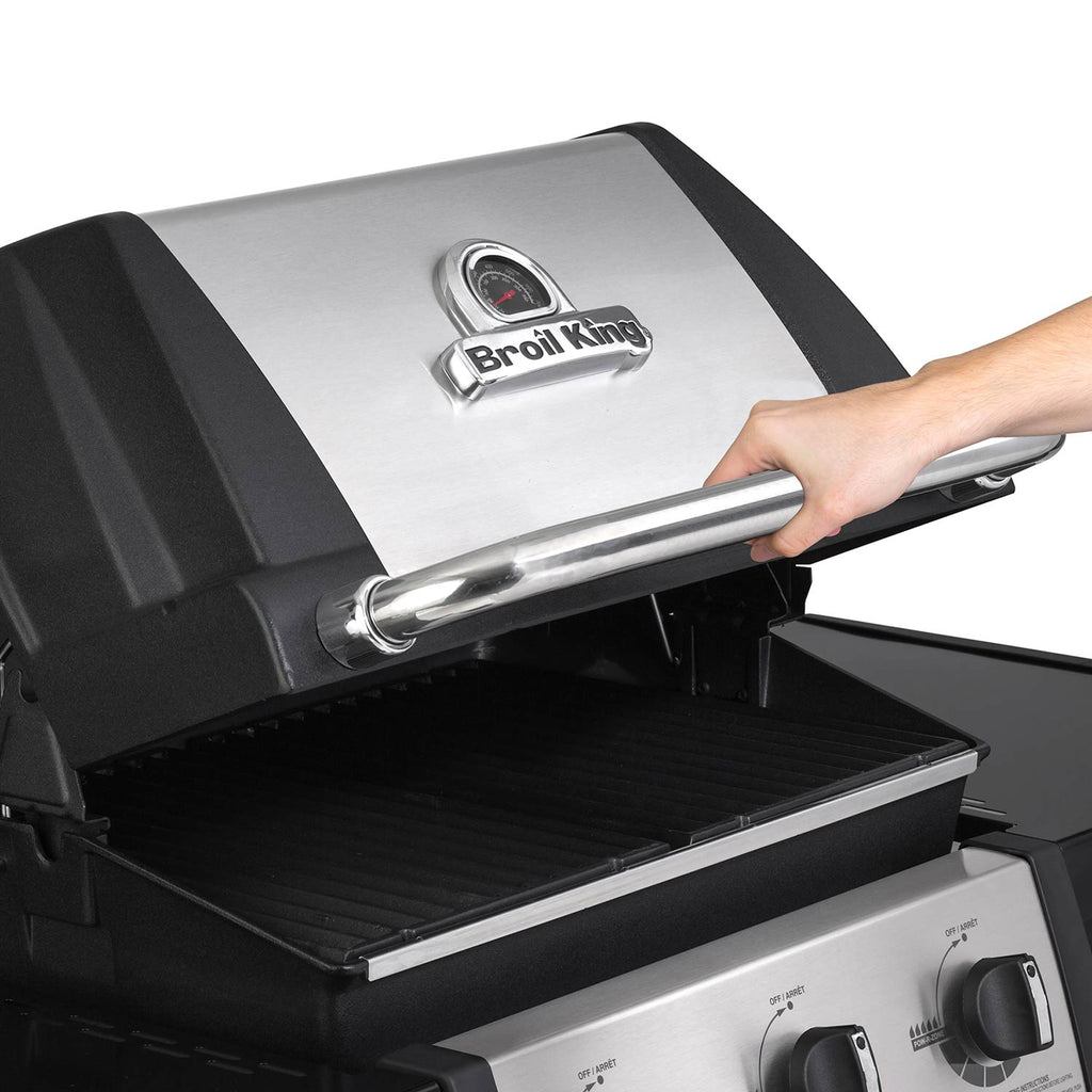 Gas grill lid thermometer and stainless handle on black and silver cabinet