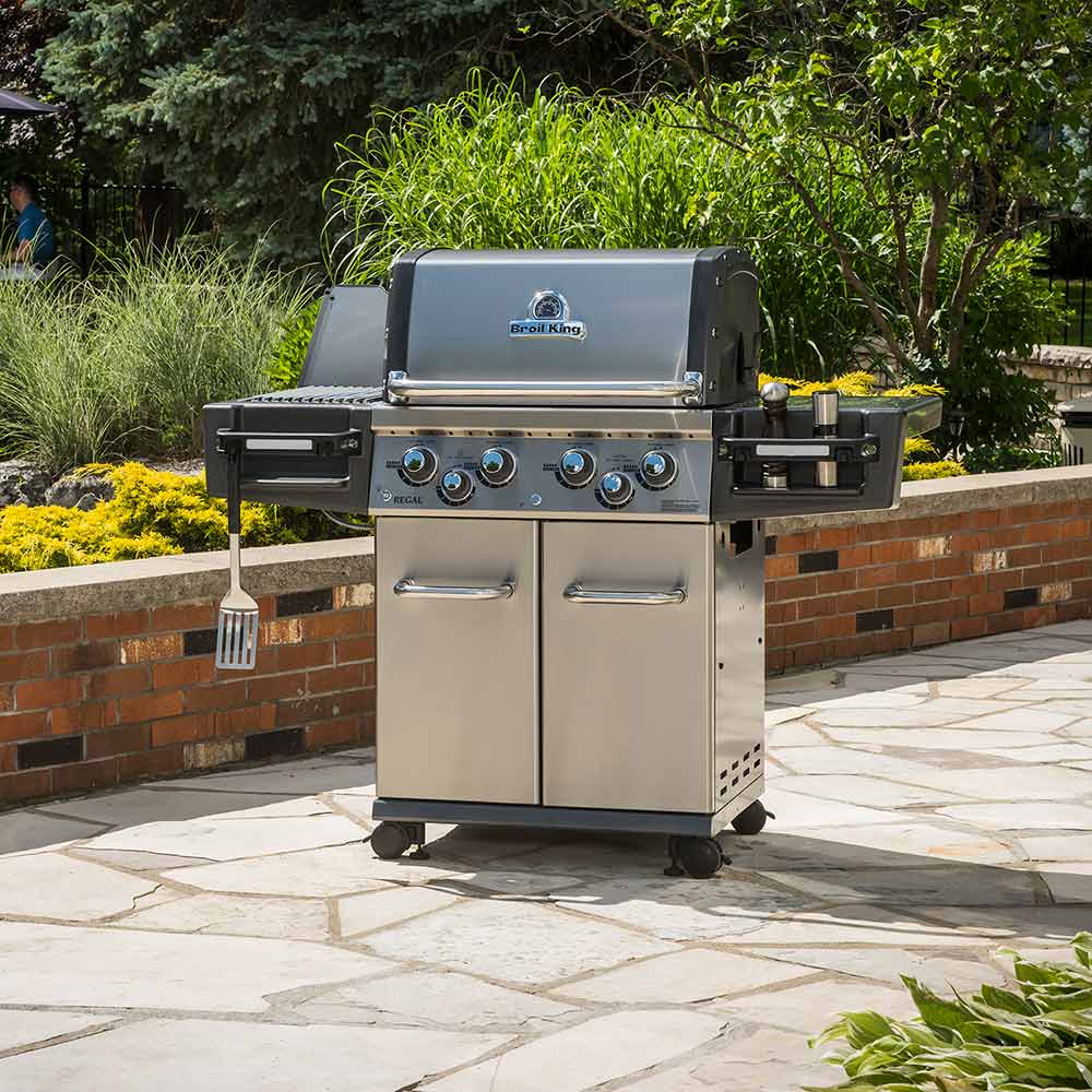 Freestanding stainless steel gas grill with four blue-lit control knobs