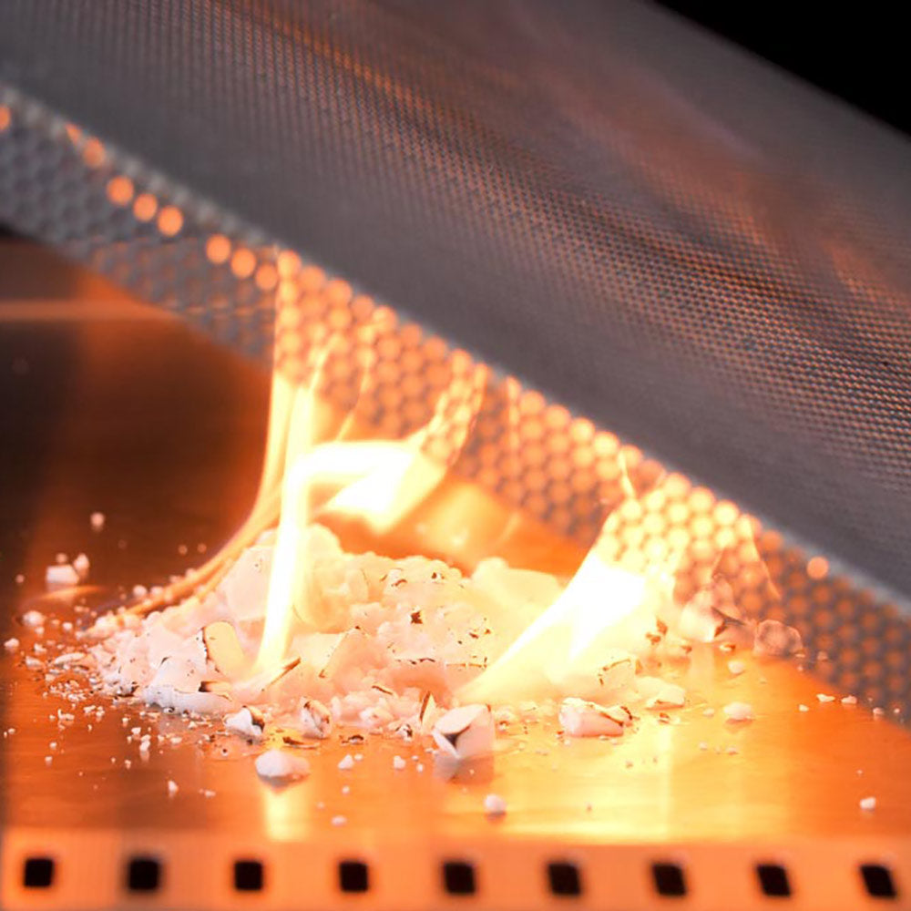 Flame rising over perforated flame guard mesh, protecting grill drip tray