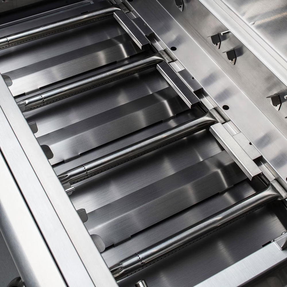 Open firebox of stainless steel gas grill with angled flavor bars