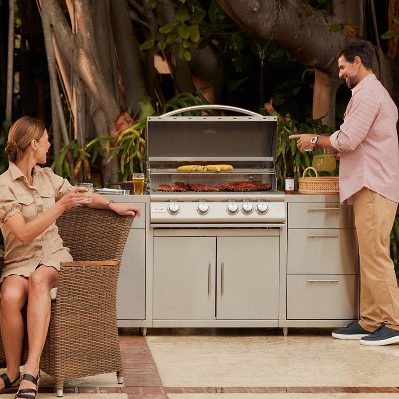Built-in gas grill with open hood and food-ready cooking surface
