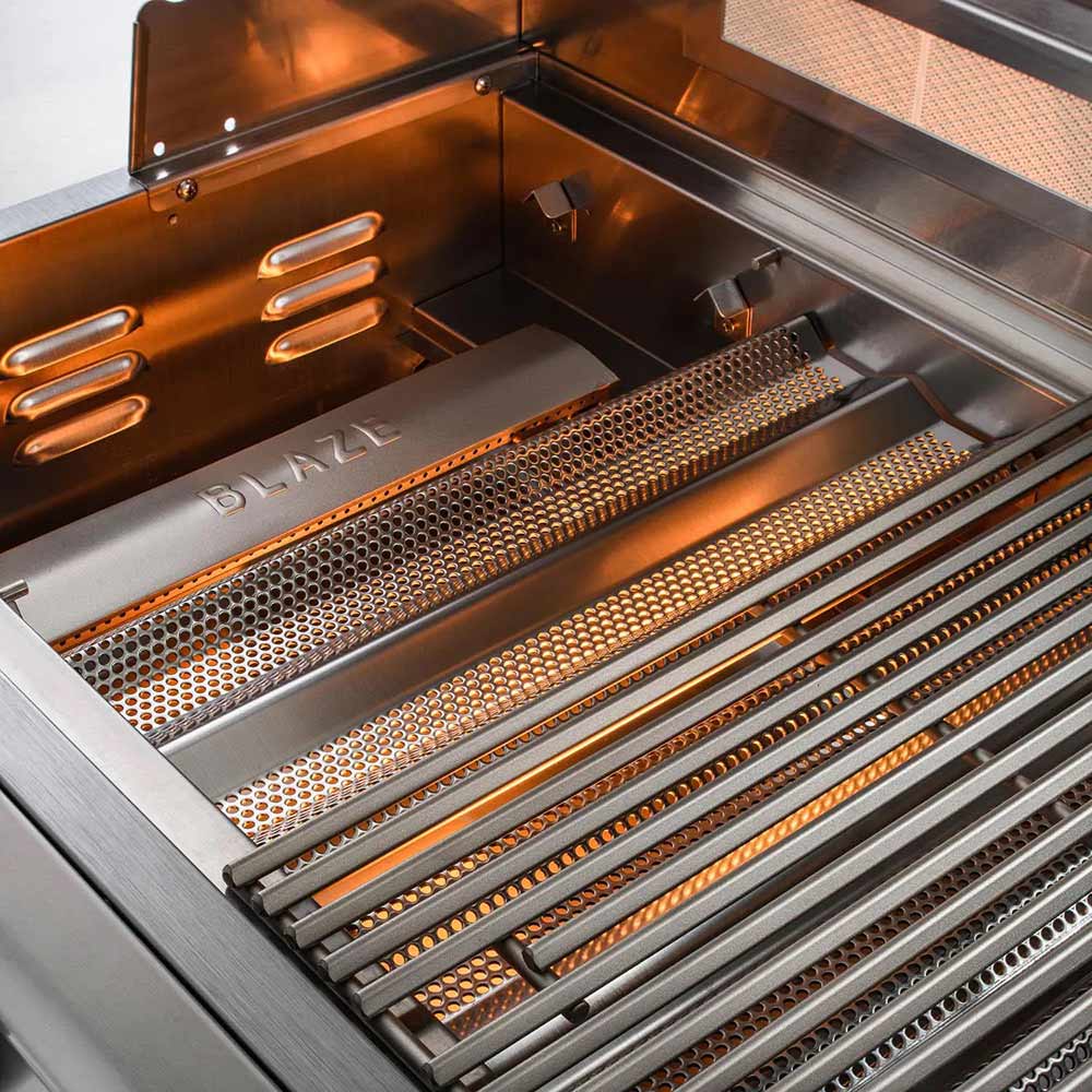 Gas grill interior with perforated burner trays and Blaze GRILLS heat shields