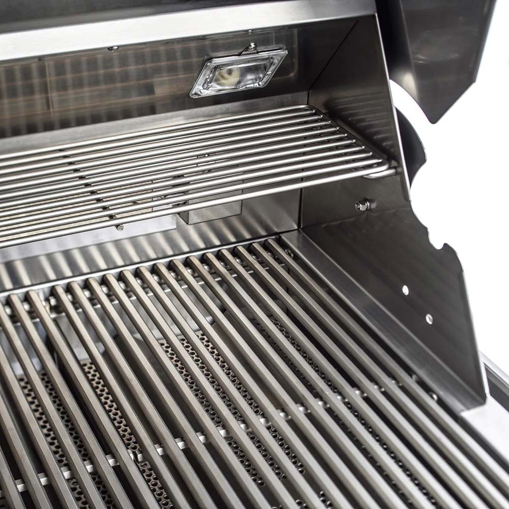 Open stainless grill showing cooking grates and warming rack inside the lid