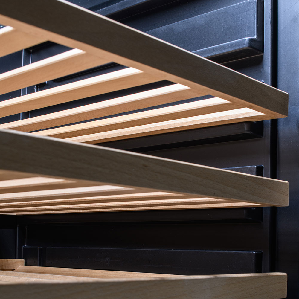 Wooden bottle rack slats inside a glass-door beverage cooler interior