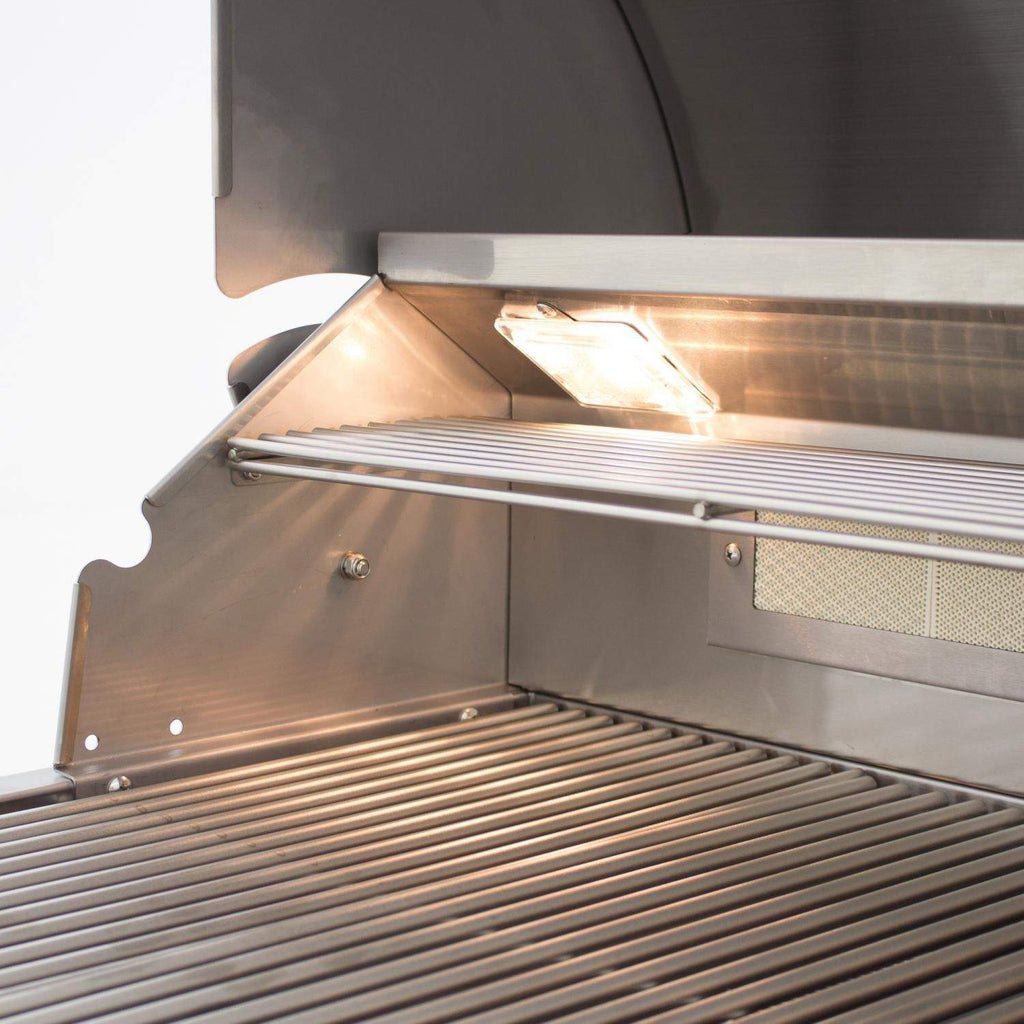Gas grill cooking grates inside open lid with lit overhead warming light