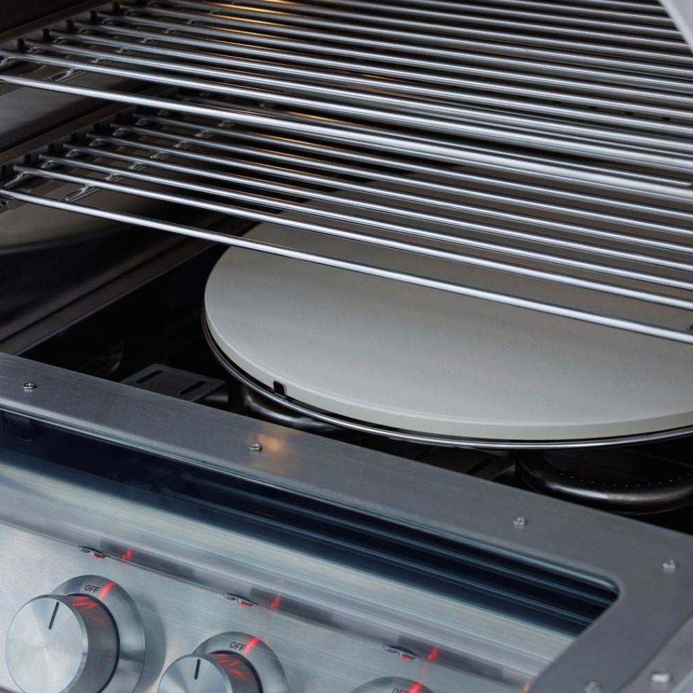 Pizza oven cooking grate with glowing heat shields and side burner control row