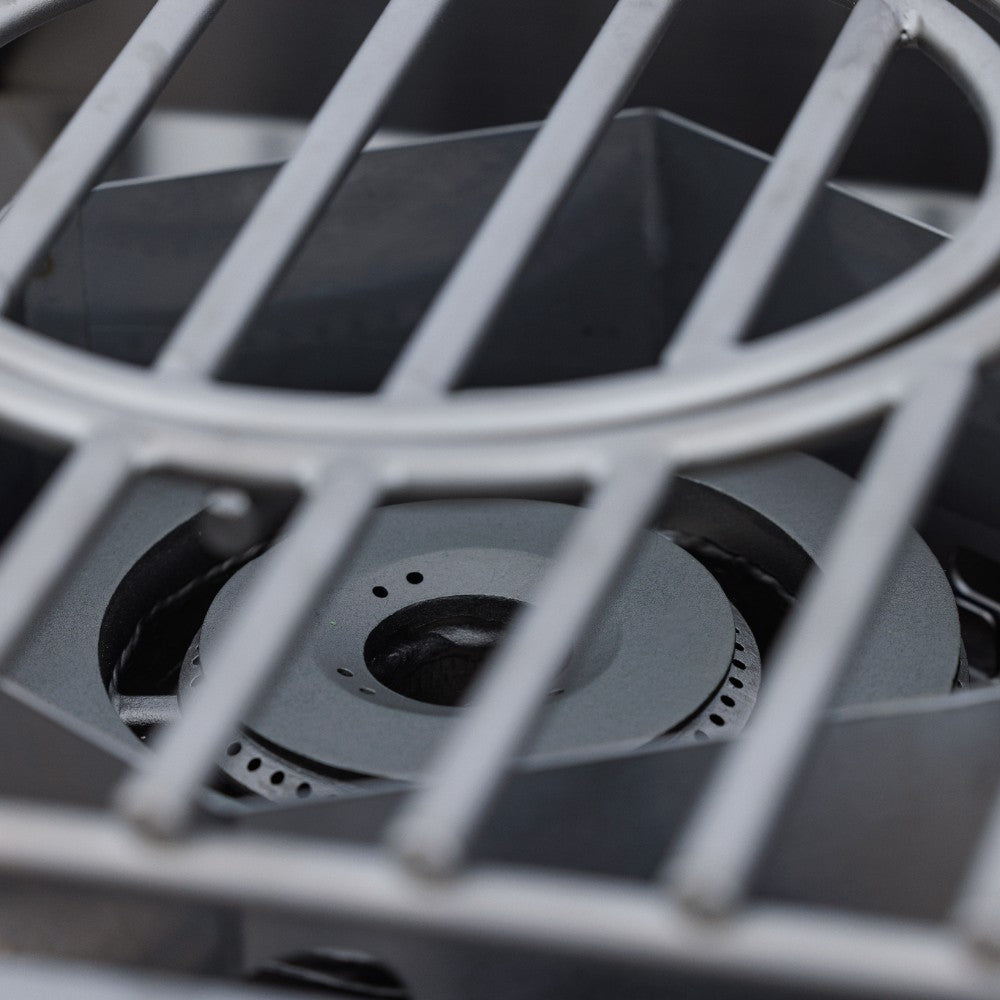 Burner head with flame ports under stainless steel grate